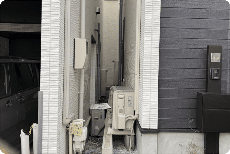 建物の狭い隙間に挟まれたように設置された室外機の例。